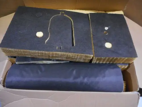 Isoliermaterialien in einem Karton, featuring schwarze Platten und gelbe Füllung, geeignet für Kesselkörper-Isolierung. Hersteller: Remeha.